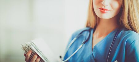 Portrait of woman doctor with folder at hospital corridorの写真素材