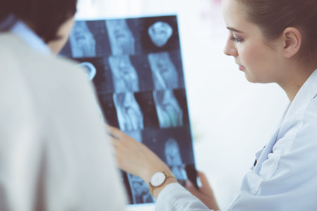 Young doctors studying X-ray images in clinic