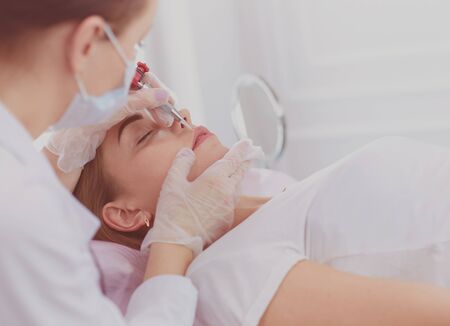 A young girl having red lips permanent makeup, micropigmentationの写真素材