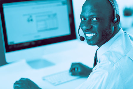 African american businessman on headset working on his laptop