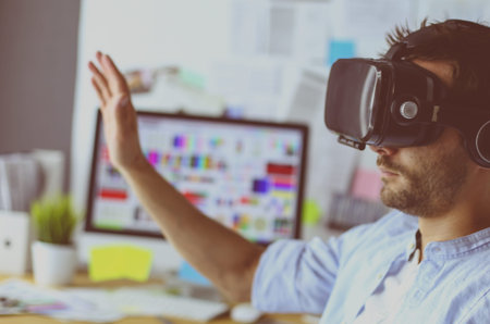 Young male software programmer testing a new app with 3d virtual reality glasses in office.