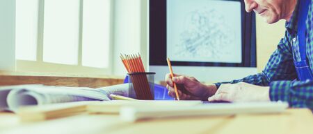 Architect working on drawing table in office.の写真素材