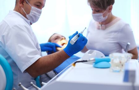 Detail of hand holding dental tools in dental clinic. Dentist Concept.の写真素材