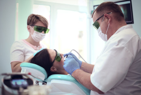 Portrait of a dentist who treats teeth of young woman patient.の写真素材