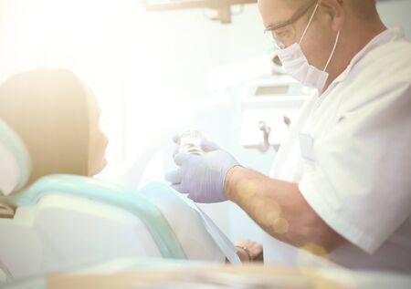 Image of young lady with dentist over her before checking oral cavity.の写真素材