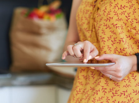 beautiful young woman using a digital tablet in the kitchen.