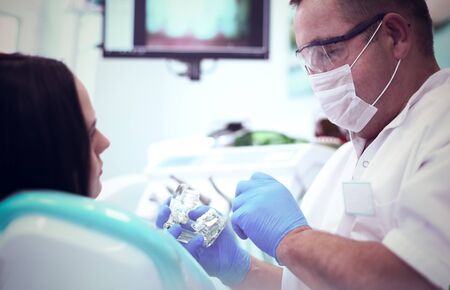 Dentist and his assistant carrying out a thorough examination.の写真素材