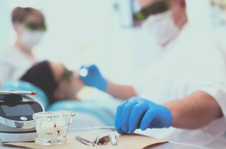 Senior male dentist adjust searchlight before starting work.の写真素材