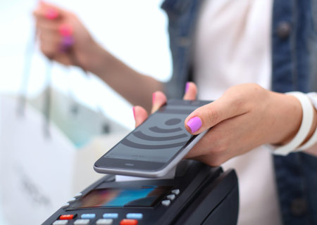 Customer is paying with smartphone in shop using NFC technology. NFC technology. Customer is paying.