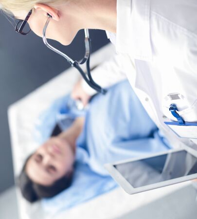 Doctor and patient discussing something while sitting at the table . Medicine and health care conceptの写真素材