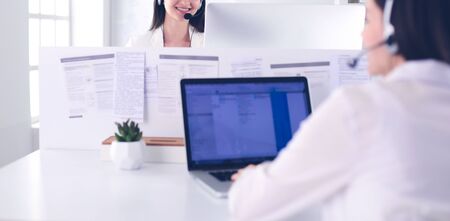 Smiling businesswoman or helpline operator with headset and computer at office.の写真素材