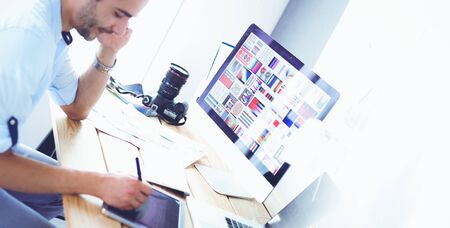 Portrait of young designer sitting at graphic studio in front of laptop and computer while working onlineの写真素材