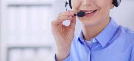 Serious pretty young woman working as support phone operator with headset in office.の写真素材