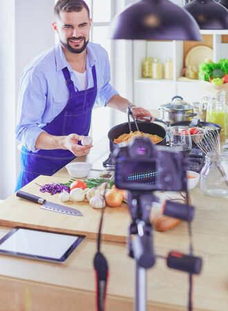 Man holding paper bag full of groceries on the kitchen background. Shopping and healthy food conceptの写真素材