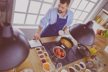 Man preparing delicious and healthy food in the home kitchenの写真素材