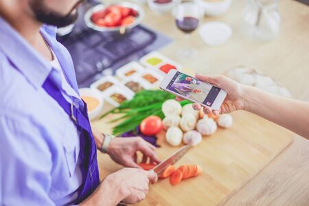 Man preparing delicious and healthy food in the home kitchen.の写真素材