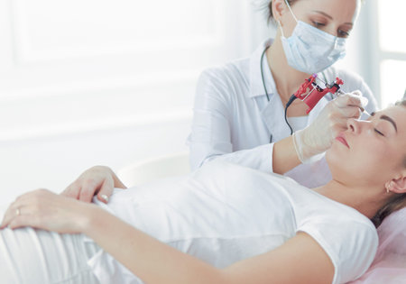 A young girl having red lips permanent makeup, micropigmentation