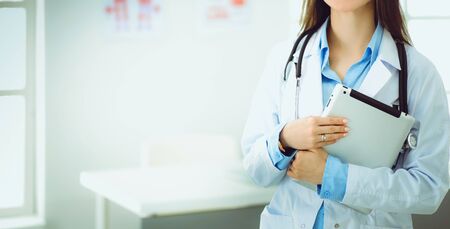 Female doctor using tablet computer in hospital lobby.の写真素材