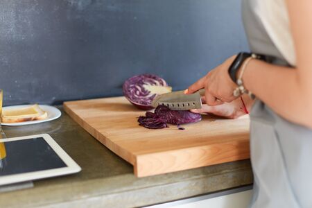 Young woman using a tablet computer to cook in her kitchen.の写真素材