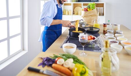 Man preparing delicious and healthy food in the home kitchen.の写真素材