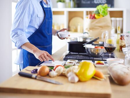 Man preparing delicious and healthy food in the home kitchen.の写真素材