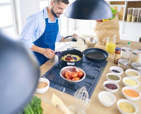 Man preparing delicious and healthy food in the home kitchenの写真素材