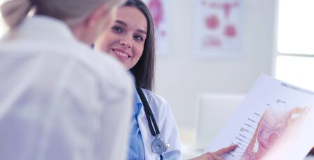 Doctor and patient discussing something while sitting at the table . Medicine and health care conceptの写真素材