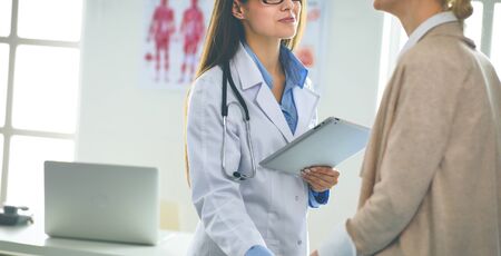 Doctor and patient discussing something while sitting at the table . Medicine and health care conceptの写真素材