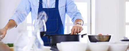 Man preparing delicious and healthy food in the home kitchen.の写真素材
