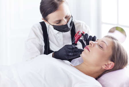 Cosmetologist applying permanent make up on eyebrows.の写真素材
