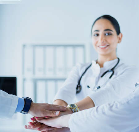 Doctors and nurses in a medical team stacking handsの写真素材