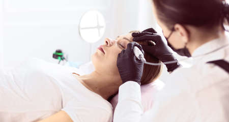 Microblading eyebrows work flow in a beauty salon.の写真素材
