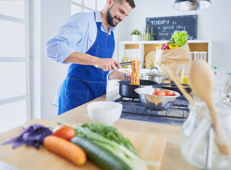 Man preparing delicious and healthy food in the home kitchenの写真素材