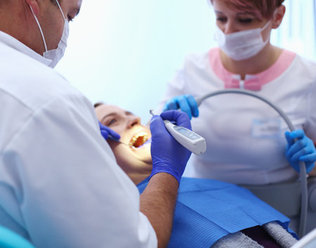 Portrait of a dentist who treats teeth of young woman patient