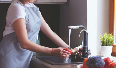 Hands of woman washing vegetables at her kitchenの写真素材