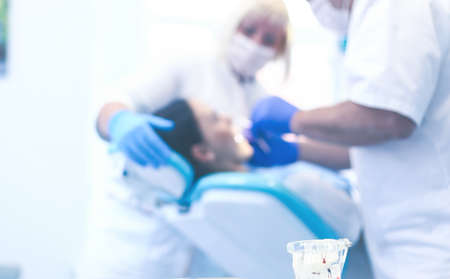 Dentist and his assistant carrying out a thorough examinationの写真素材