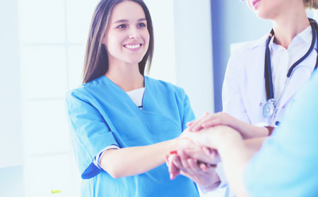 Doctors and nurses in a medical team stacking hands