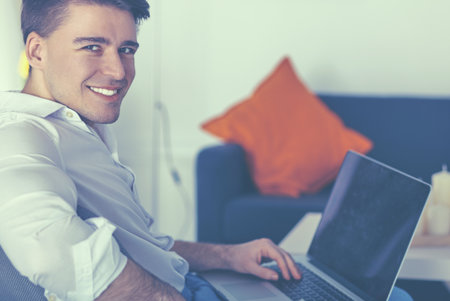 Young businessman working in office, sitting at deskの写真素材