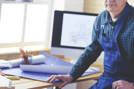 Architect working on drawing table in officeの写真素材