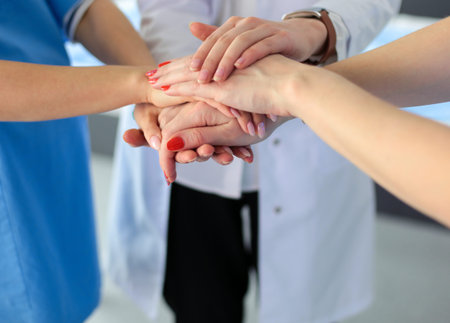 Doctors and nurses in a medical team stacking hands