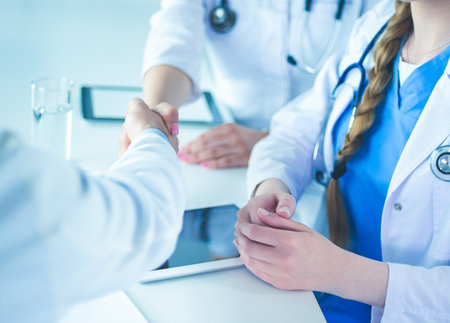 Doctor shakes hands with a patient isolated on white backgroundの写真素材