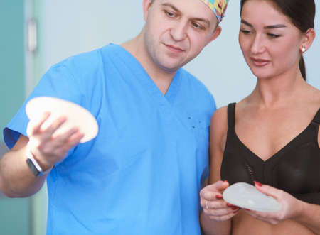 Doctor showing young patient her chest in his office at the hospitalの写真素材