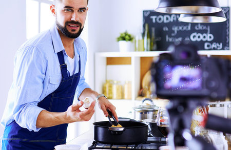 Man holding paper bag full of groceries on the kitchen background. Shopping and healthy food conceptの写真素材