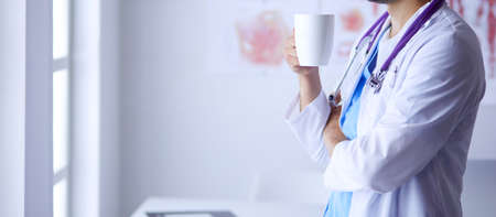Young and confident male doctor portrait standing in medical office.の写真素材