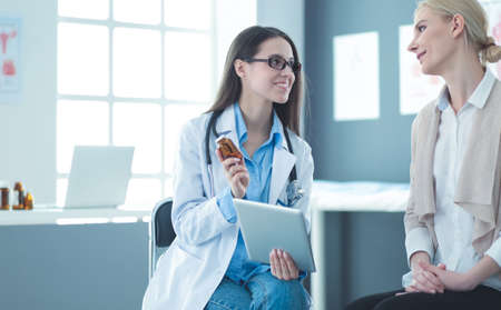 Doctor and patient discussing something while sitting at the table . Medicine and health care conceptの写真素材