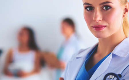 Woman doctor standing with folder at hospitalの写真素材