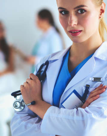 Woman doctor standing with folder at hospitalの写真素材