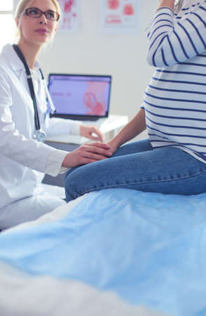 Beautiful smiling pregnant woman with the doctor at hospitalの写真素材