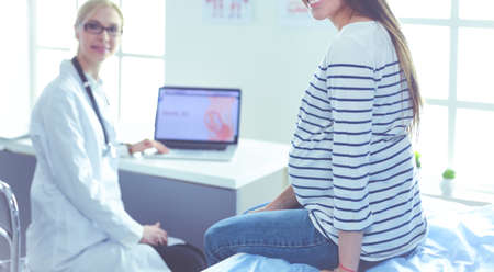 Beautiful smiling pregnant woman with the doctor at hospitalの写真素材