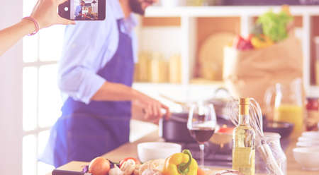 Portrait of handsome man filming cooking show or blogの写真素材